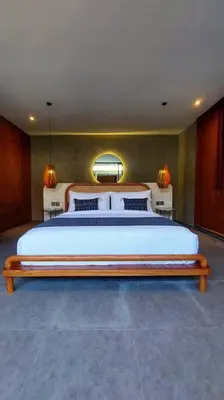 a bedroom with a large bed and two lamps at Akhila 1 - 1 BR modern tropical villa at the heart of Seminyak in Seminyak