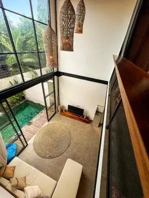 a living room with a view of a swimming pool at Tropical Loft Steps Away from the Beach! Hidden GEM! in Canggu
