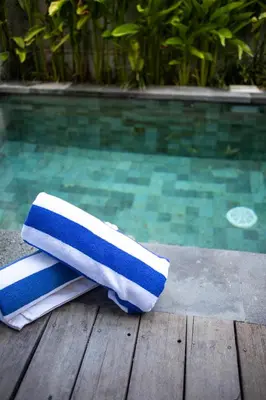 a pair of towels sitting on a table next to a swimming pool at Tropical Loft Steps Away from the Beach! Hidden GEM! in Canggu