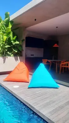 a house with a swimming pool with a blue and orange object at Akhila 4 - 1 BR modern tropical villa at the heart of Seminyak in Seminyak