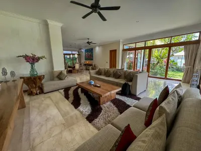 a living room with couches and a coffee table at Tranquil Classic Balinese Villa in Badung