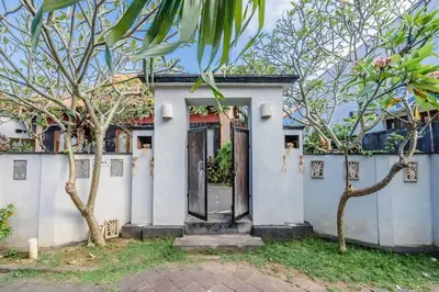 a white house with a door and some trees at Private 3 Bedroom Villas, 5 mnt to Beach Nusa Dua in Nusa Dua