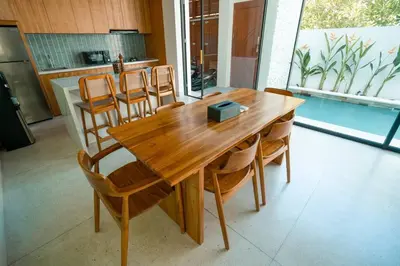 a wooden table and chairs in a kitchen at Pradha Kuta, 3 BDR, 3 minutes from seminyak beach in Seminyak