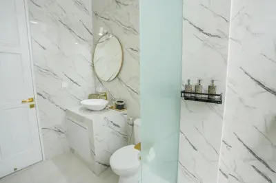 two images of a bathroom with a toilet and a mirror at Stunning tropical 3bed Villa in Canggu