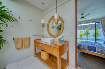 a bathroom with a sink and a mirror at Chic Tranquility Modern yet Timeless 3BD Villa in Canggu