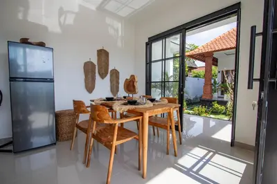 a dining room with a wooden table and chairs at Viewbali 1 - Villa with Jungle Garden Big Pool and Kitchen in Kerobokan