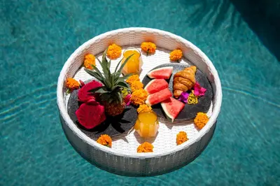 a bowl of food on a plate next to a pool at Sunterra Villa with Ricefield View in Canggu in Kerobokan