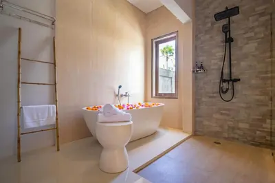 a bathroom with a tub and a toilet and a shower at Sunterra Villa with Ricefield View in Canggu in Kerobokan