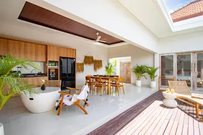 a kitchen and dining room with a table and chairs at Sunterra Villa with Ricefield View in Canggu in Kerobokan