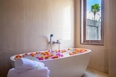 a bath tub covered in flowers in a bathroom at Sunterra Villa with Ricefield View in Canggu in Kerobokan