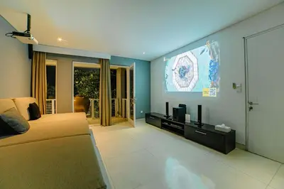 a living room with a couch and a flat screen tv at CassaMia Bali - Spacious Luxury 5 Bedroom Villa in Jimbaran