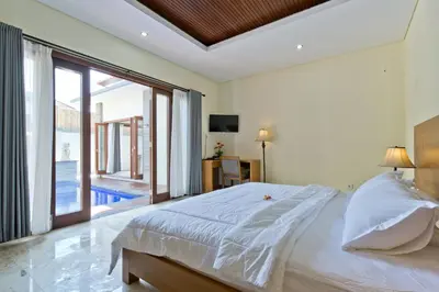 a bedroom with a large bed and a large window at Seminyak Villa in Seminyak