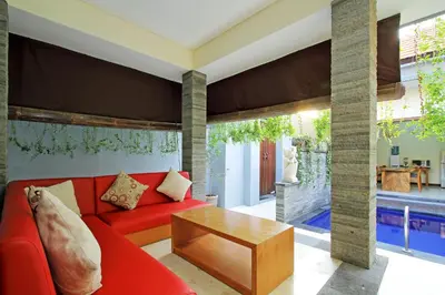 a living room with a red couch and a table at Seminyak Villa in Seminyak