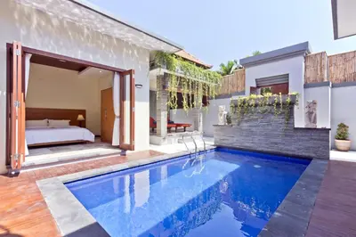 a villa with a swimming pool and a bedroom at Seminyak Villa in Seminyak