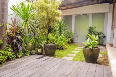a garden with plants and a wooden walkway at Villa Marie Clare in Seminyak