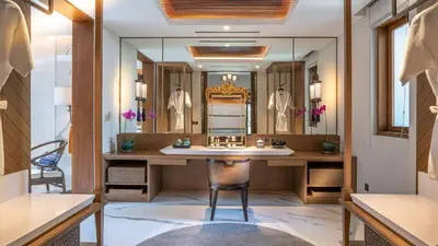 a dressing room with a vanity and a mirror at Des Indes Villas in Seminyak