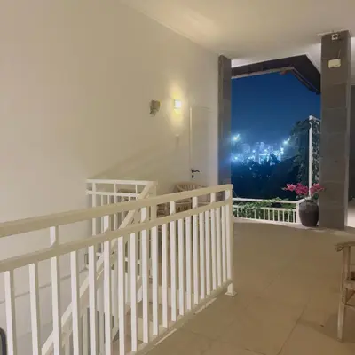 a balcony with a view of a city at night at Adijaya Rooms in Seminyak