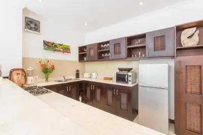 a kitchen with wooden cabinets and a white refrigerator at 2 Bedroom Private Pool walking distance to the Seminyak beach in Seminyak