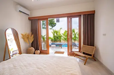 a bedroom with a bed and a view of a pool at Kubung 1 - Villa with HUGE Pool and PS5 in Kerobokan