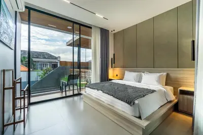 a bedroom with a large bed and a balcony at Villa Elena by Maheswara in Seminyak
