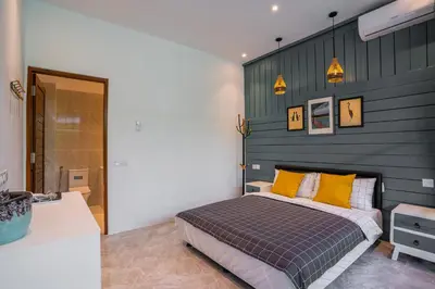 a bedroom with a bed with a blue wall at NEW! Villa Sony 2 - 3BR villa next to Legian Beach in Seminyak