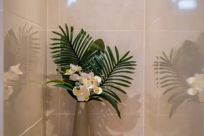 a vase filled with white flowers in a bathroom at NEW! Villa Sony 2 - 3BR villa next to Legian Beach in Seminyak