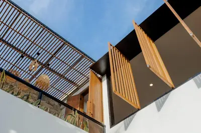 a house with a balcony with wooden railing at Vin Villa Seminyak 2BR with Private Pool in Seminyak