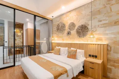 a bedroom with a bed and a stone wall at Vin Villa Seminyak 2BR with Private Pool in Seminyak