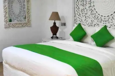a white bed with green pillows in a bedroom at Rose 2BR Private Pool Villa in Kerobokan