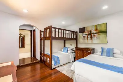 a bedroom with two bunk beds and a mirror at Rose 2BR Private Pool Villa in Kerobokan