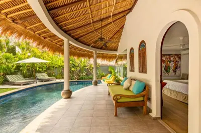 a villa with a swimming pool and a bedroom at Hazel Azalea 4 BR Private Pool Villa in Seminyak