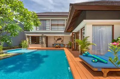 a villa with a swimming pool in front of a house at Luxury 3 BR Private Pool Villa in Seminyak