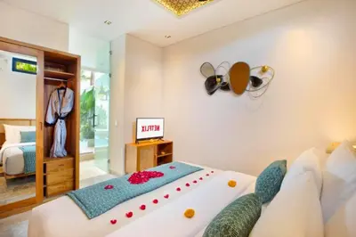 a bedroom with a large bed and a room with a bed sqor at Modern 3 BR Private Pool Villa in Legian