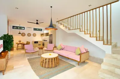 a living room with a pink couch and a staircase at Modern 3 BR Private Pool Villa in Legian