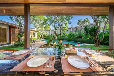 a table with plates and utensils on top of it at Villa Ayuni, Berawa in Canggu