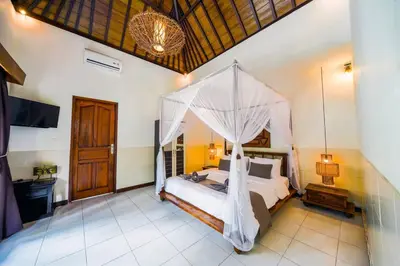 a bedroom with a bed with a mosquito net at Villa JES - 4 Bedroom Villa - Legian in Legian