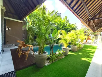 a patio with palm trees and a swimming pool at Villa JES - 4 Bedroom Villa - Legian in Legian