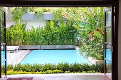 a swimming pool in a garden with plants at Cozy 2 BR Private Pool Villa in Seminyak