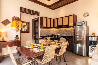 a dining room with a table and chairs in a kitchen at Cosy Traditional and Fresh 2 BD Sunterrace Villa with Pvt Pool in Kerobokan