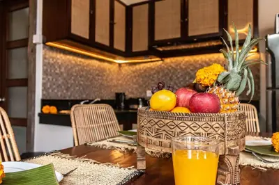 a bowl of fruit on a table with a glass of orange juice at Cosy Traditional and Fresh 2 BD Sunterrace Villa with Pvt Pool in Kerobokan