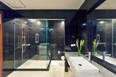 a bathroom with a shower and a toilet and a sink at Entire 3 BR Private Pool Villa in Seminyak
