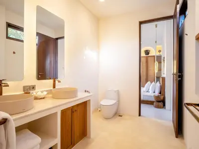 a bathroom with two sinks and a toilet at Casa Pelagos in Kerobokan