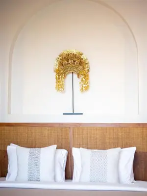 a bedroom with a bed with a wreath on the wall at Casa Pelagos in Kerobokan