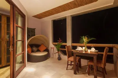 a living room with a table and a chair and a couch at Clover 3 BR Private Pool Villa in Canggu