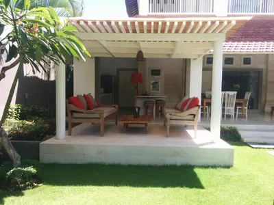 a pergola with chairs and a table in a yard at Villa Viona 4 in Seminyak