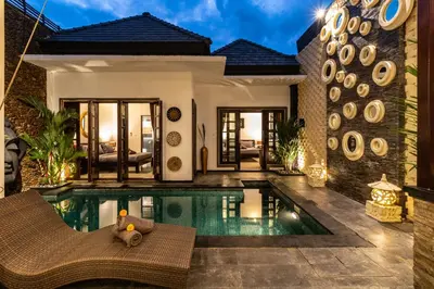 a villa with a swimming pool in front of a house at PROMO Uniquely Styled Spacious 3bd Villa in Kerobokan