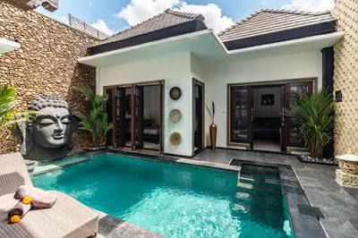 a villa with a swimming pool in front of a house at PROMO Uniquely Styled Spacious 3bd Villa in Kerobokan