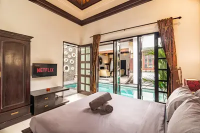 a bedroom with a bed and a view of a pool at PROMO Uniquely Styled Spacious 3bd Villa in Kerobokan
