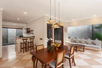 a dining room and living room with a table and chairs at Ghana Villa Seminyak by GenuineHost in Seminyak