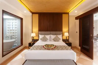 a bedroom with a large bed and a bath tub at Ghana Villa Seminyak by GenuineHost in Seminyak